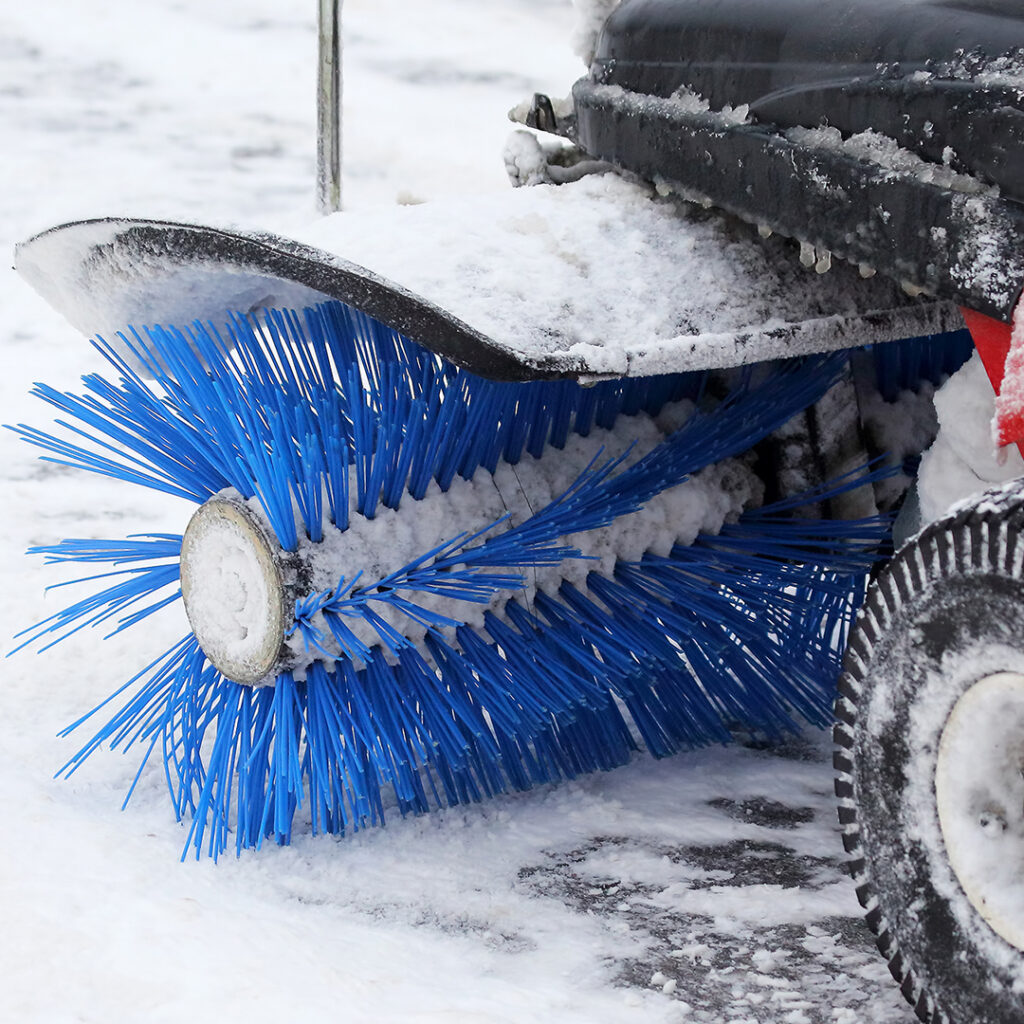 Image of a snow blower with a brush in front