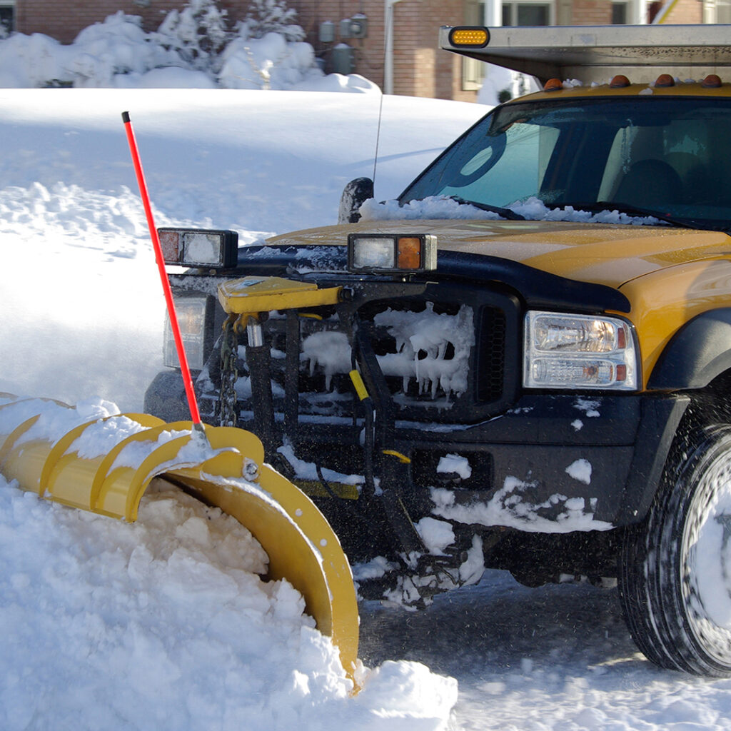 Image of a snow plow pushing a drift down the street